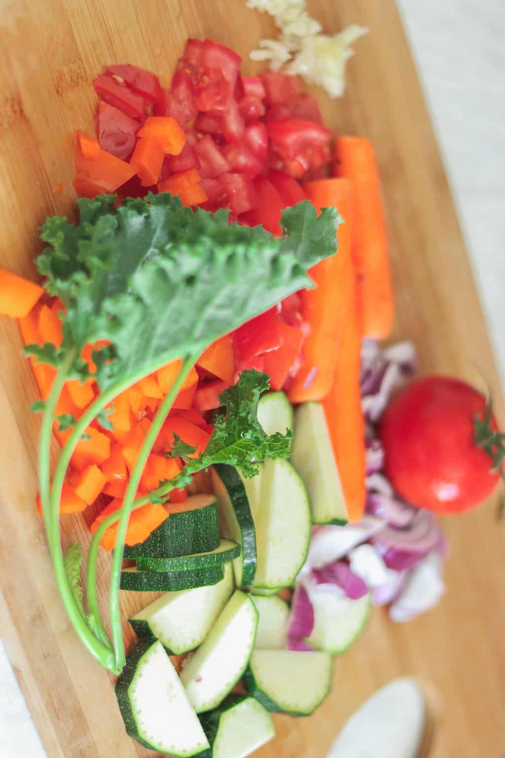 Fresh vegetables including kale mushrooms tomatoes carrots and zucchini