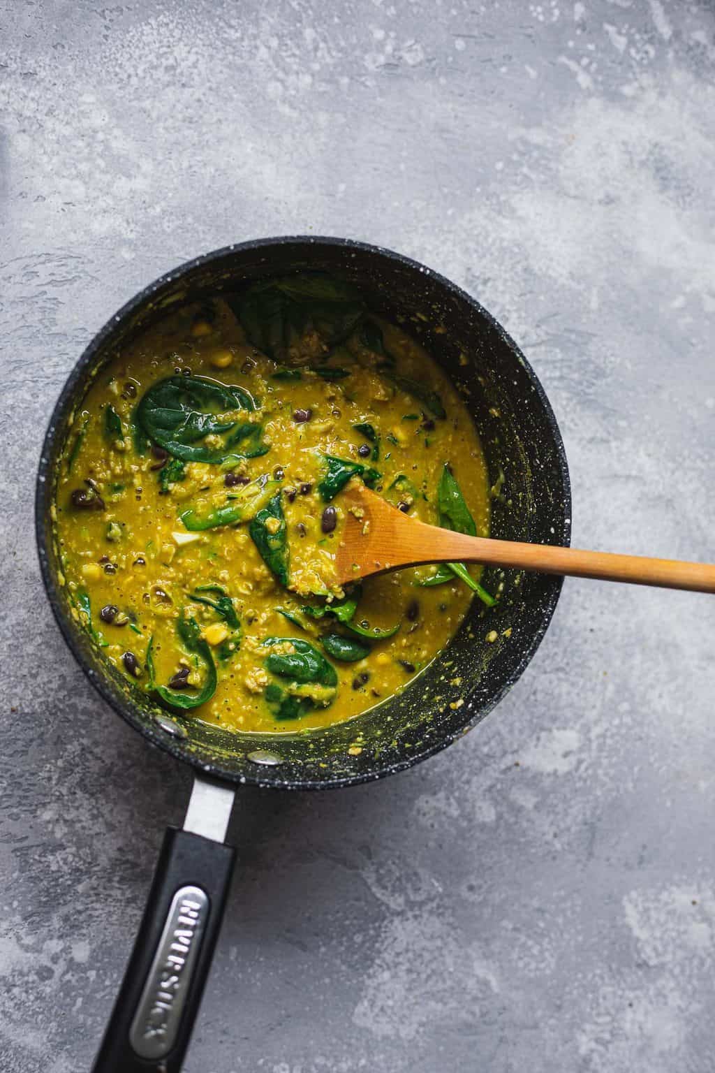 Turmeric oats with spinach in a saucepan