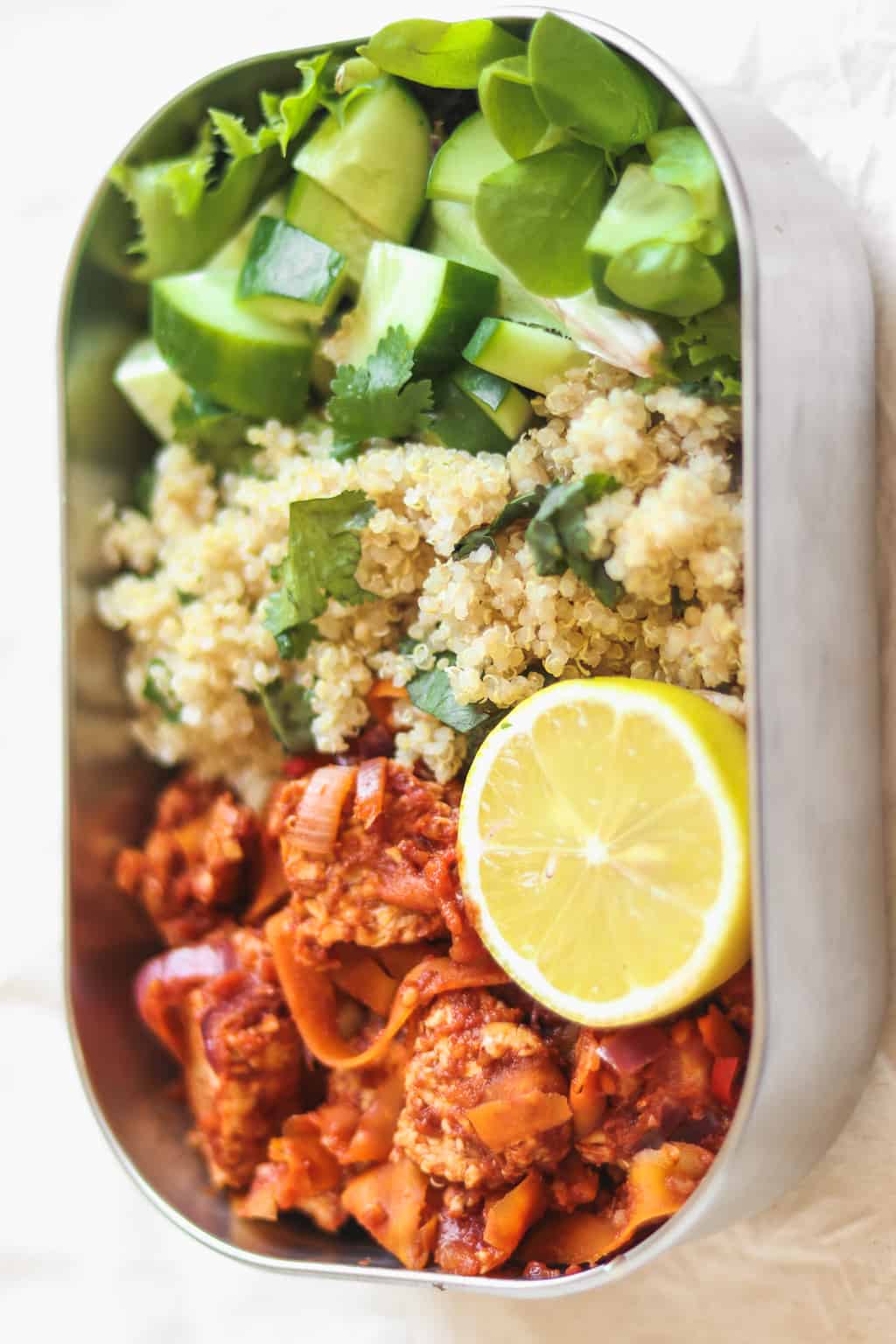 Vegan meal prep lunch box with quinoa, tempeh and a green salad 