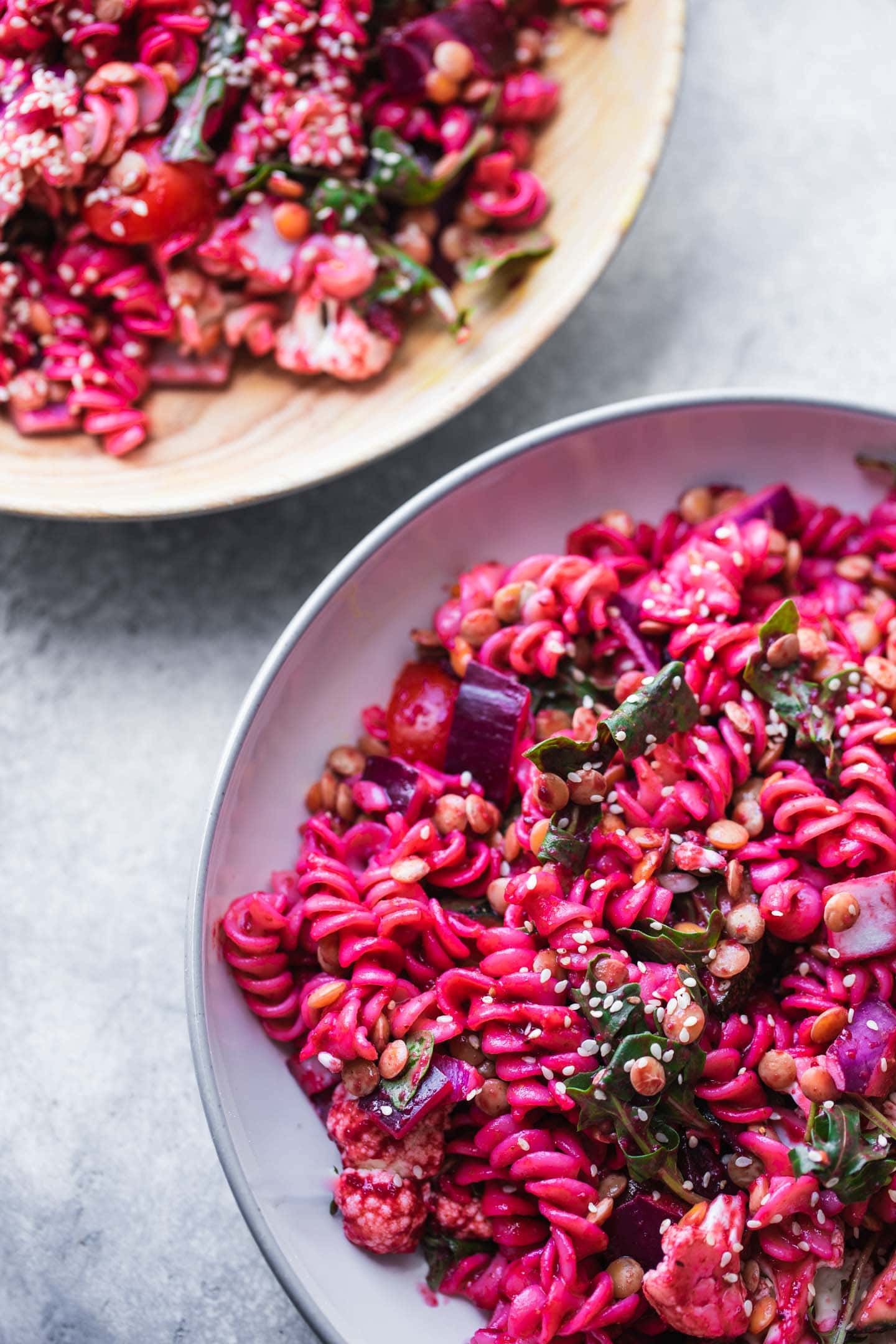 Two bowls of pasta salad with lentils and vegetables