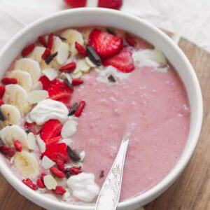 Banana and strawberry vegan protein smoothie bowl with oats and almond butter