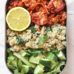 High protein meal prep lunchbox with quinoa and tempeh in a tomato sauce