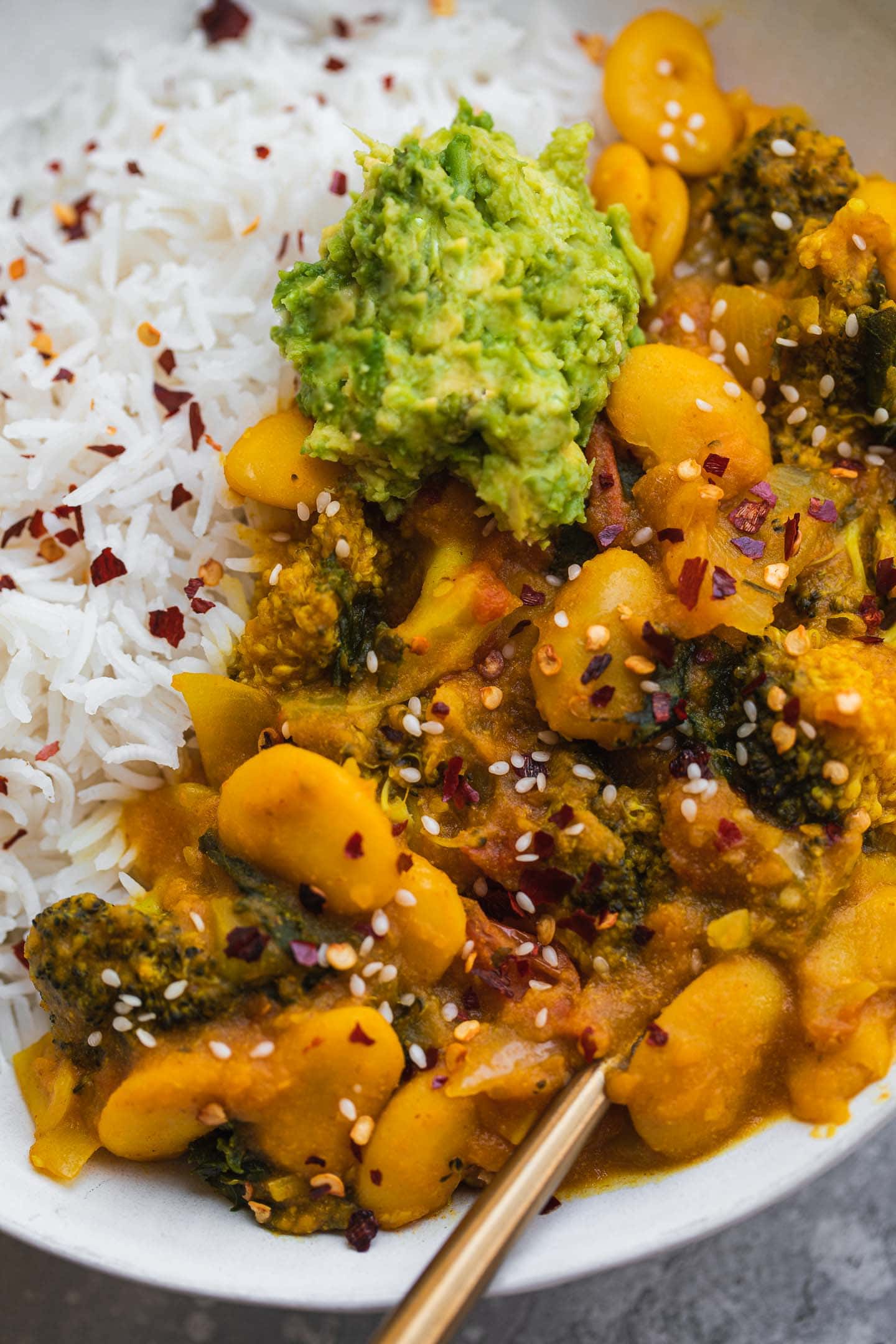 Closeup of a vegan stew with avocado and rice