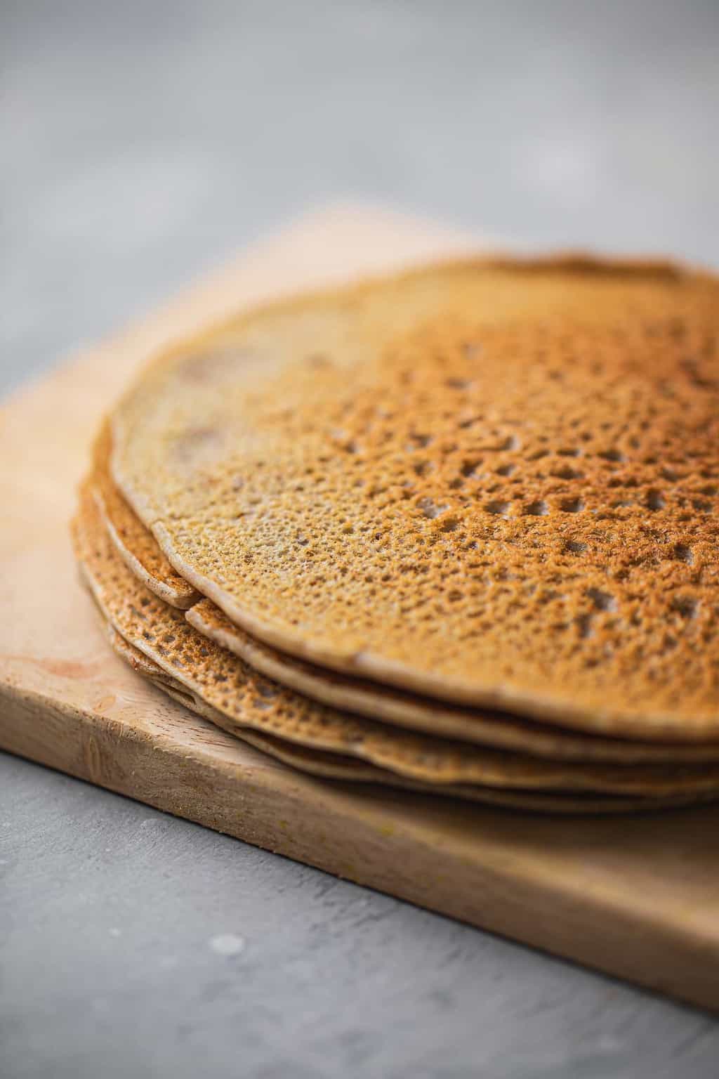 Buckwheat crepes resting on a wooden chopping board