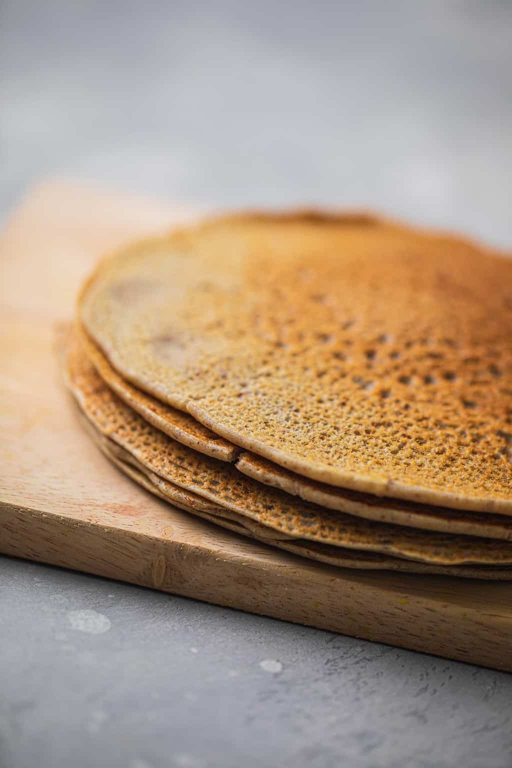 Buckwheat crepes resting on a wooden chopping board