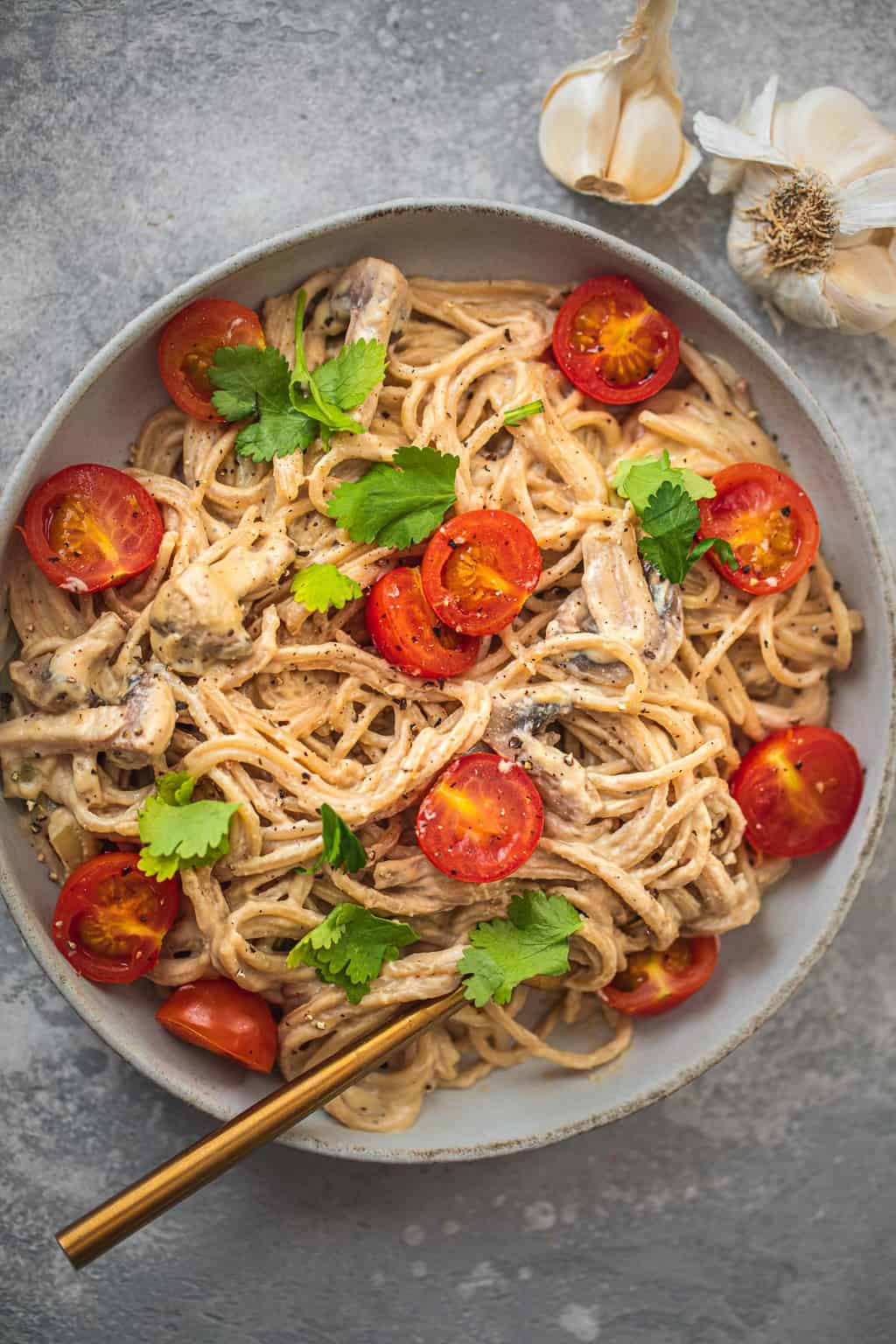 Plate of creamy vegan pasta with tomatoes