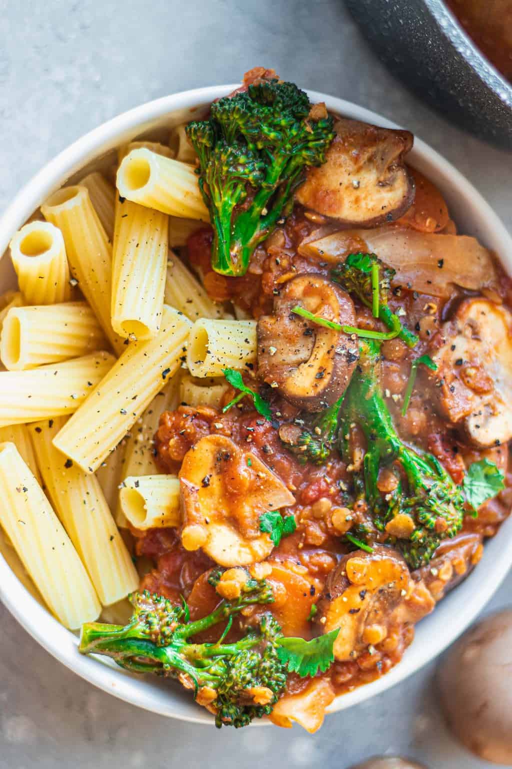 Vegan bolognese with broccoli and mushrooms in a white bowl