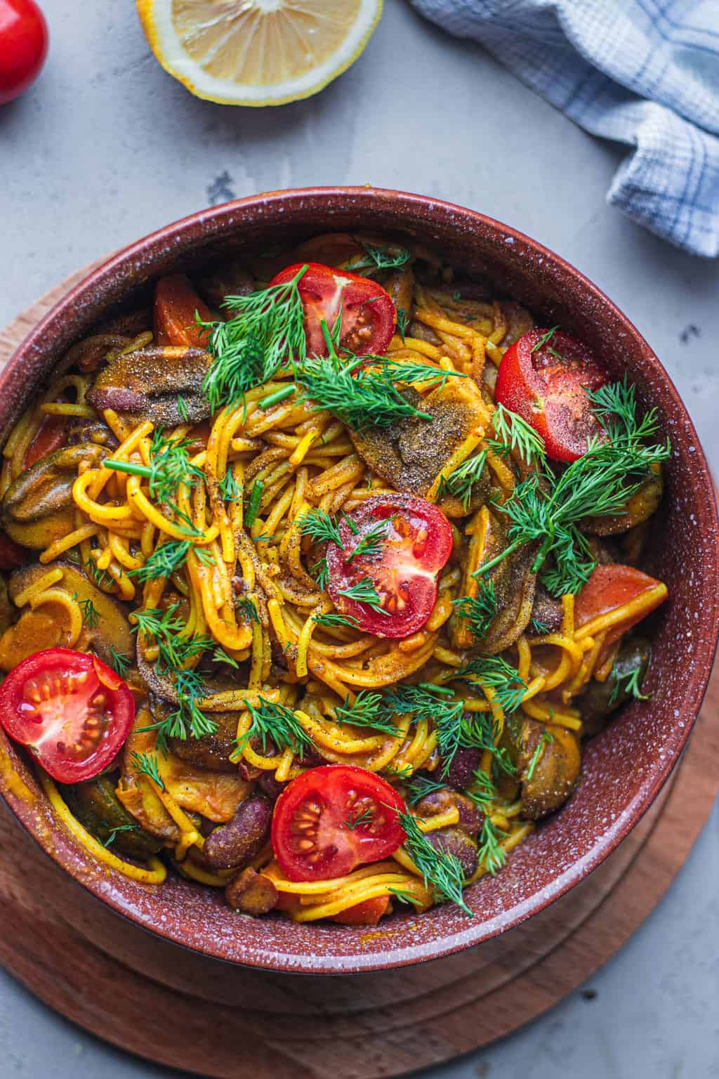 Spaghetti with beans and vegetables in a brown bowl