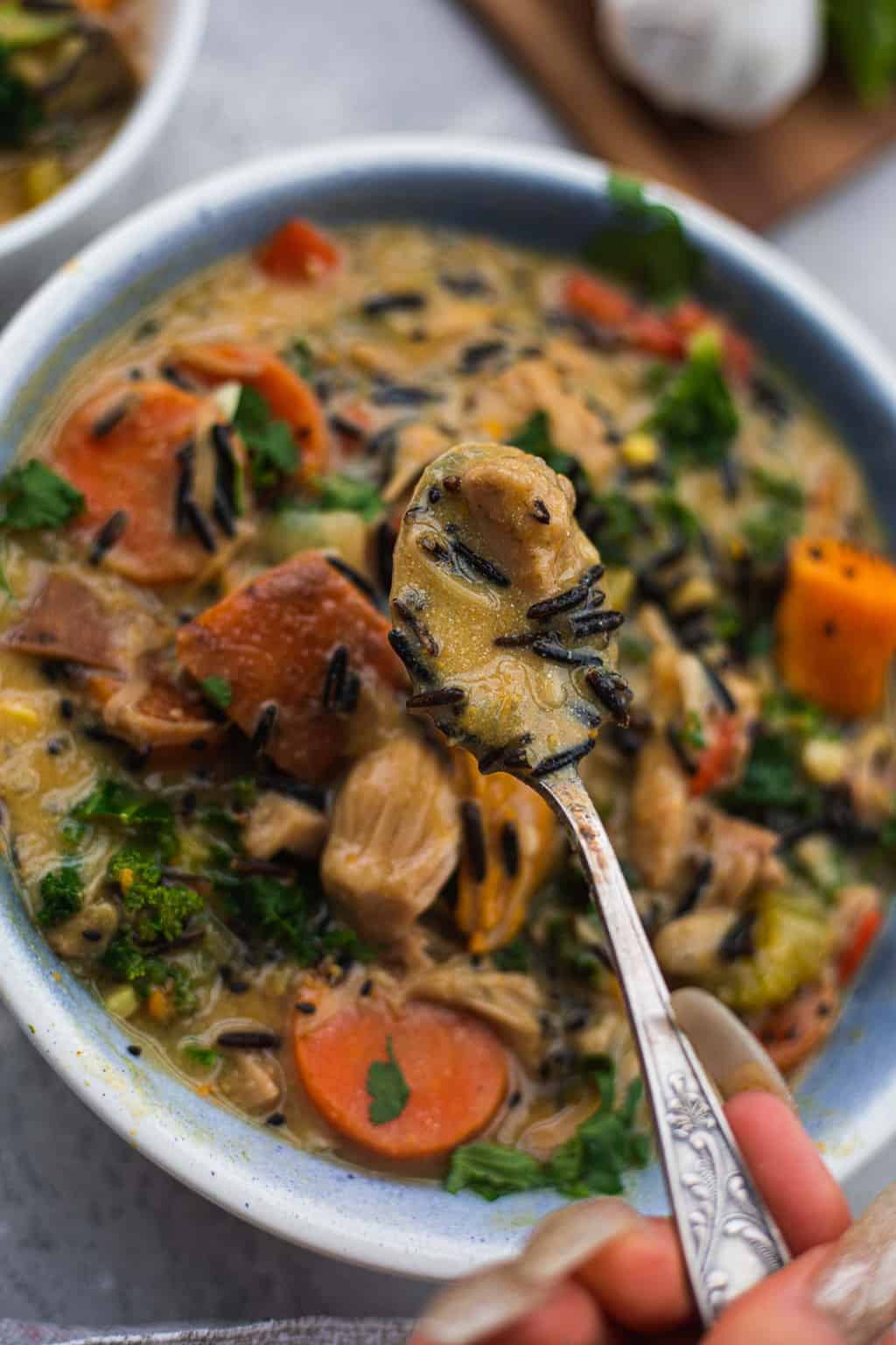 Spoon with vegan rice soup close up