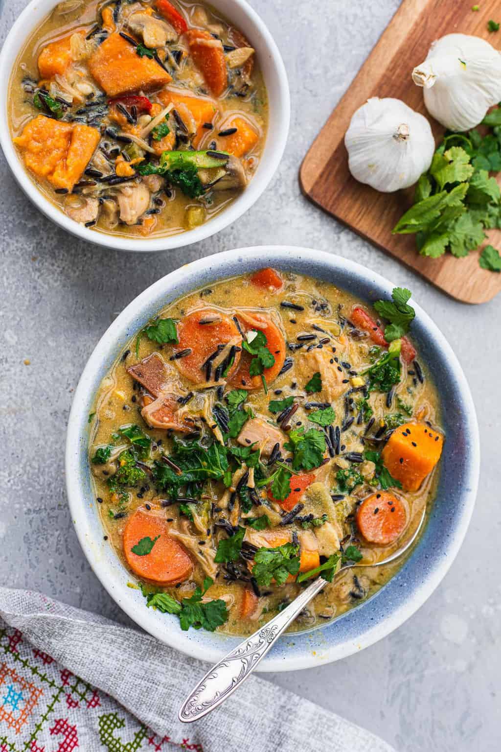 Two bowls of vegan wild rice soup with jackfruit and kale