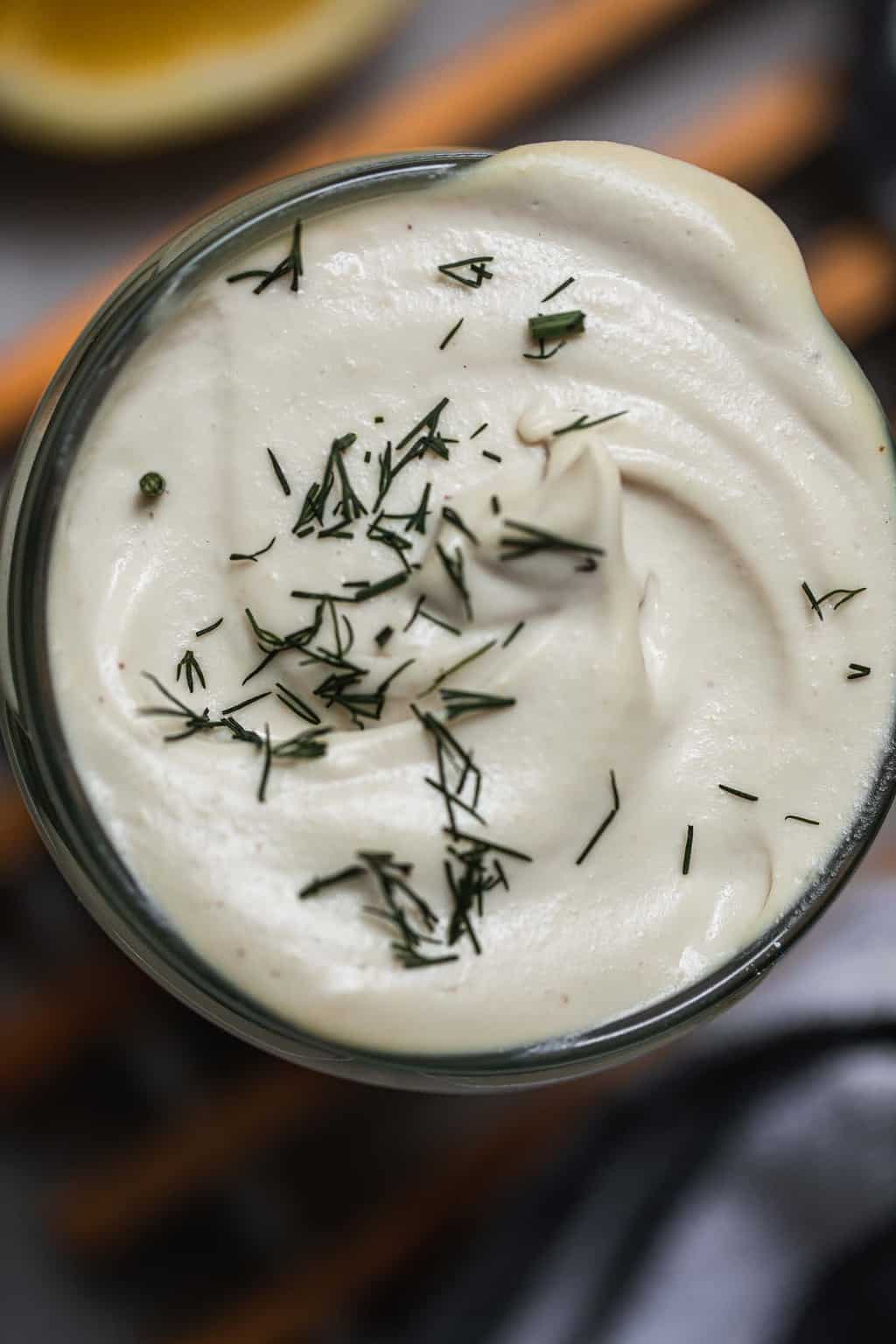 Closeup of a jar of vegan sour cream with dill