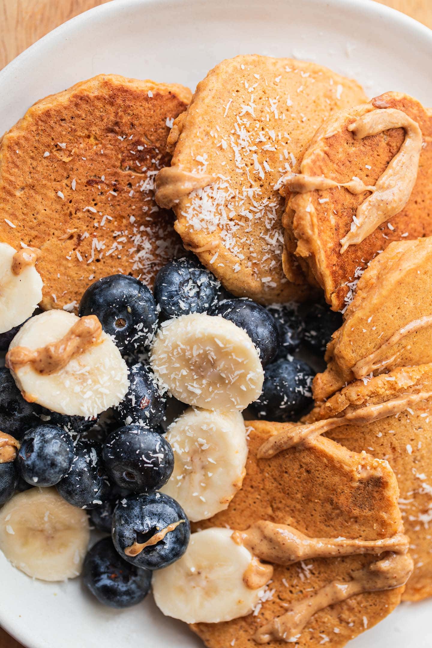 Plate of pumpkin pancakes with blueberries and banana