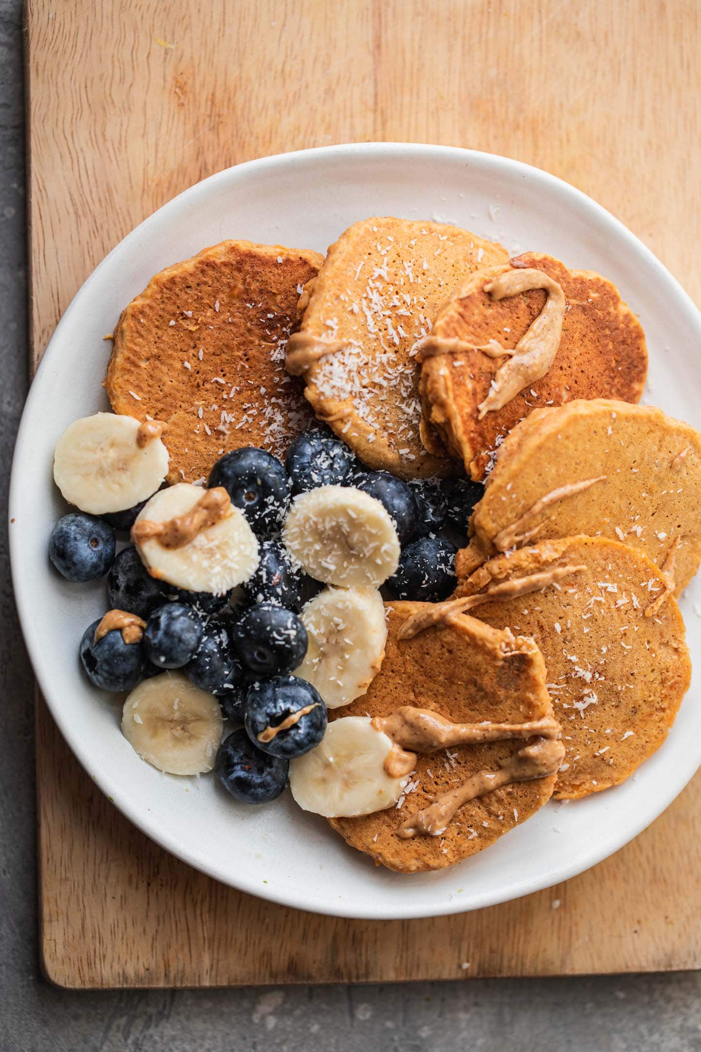 Pumpkin pancakes on a plate with fruit and almond butter