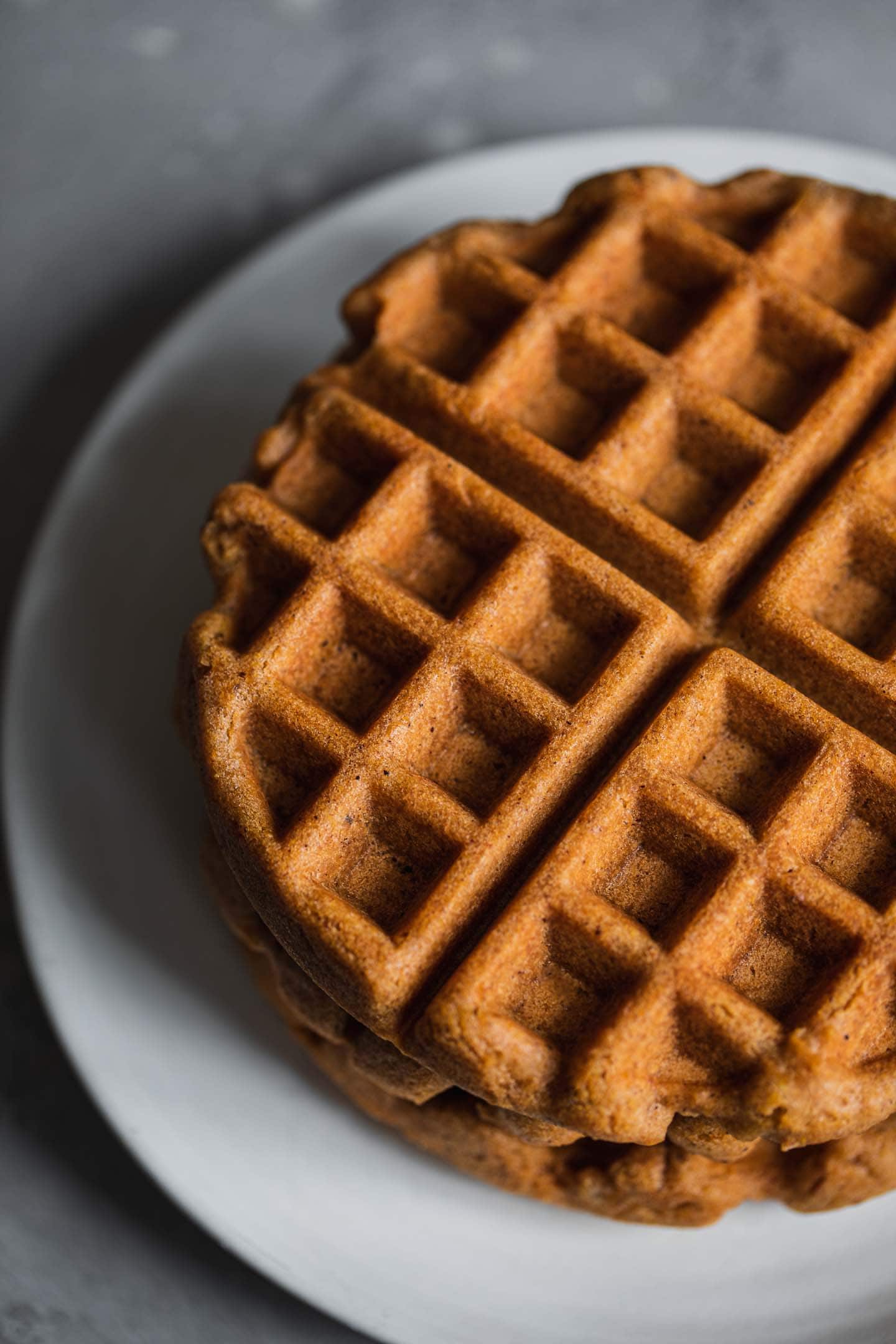 Gingerbread waffles stacked on a plate
