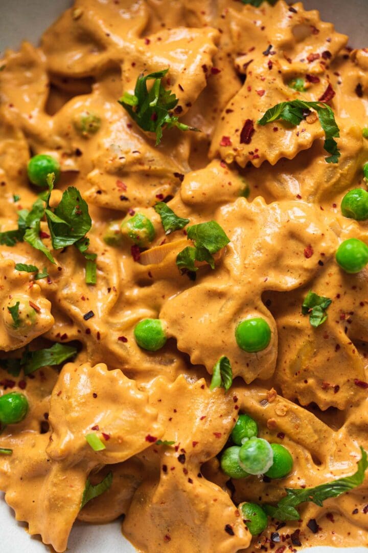 Closeup of a bowl of pasta with peas and a vegetable sauce