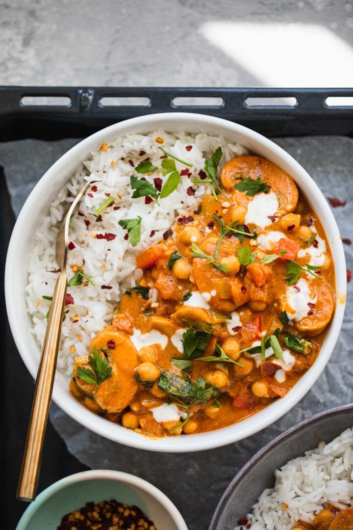 Bowl of vegan curry with chickpeas and spinach over a bed of rice
