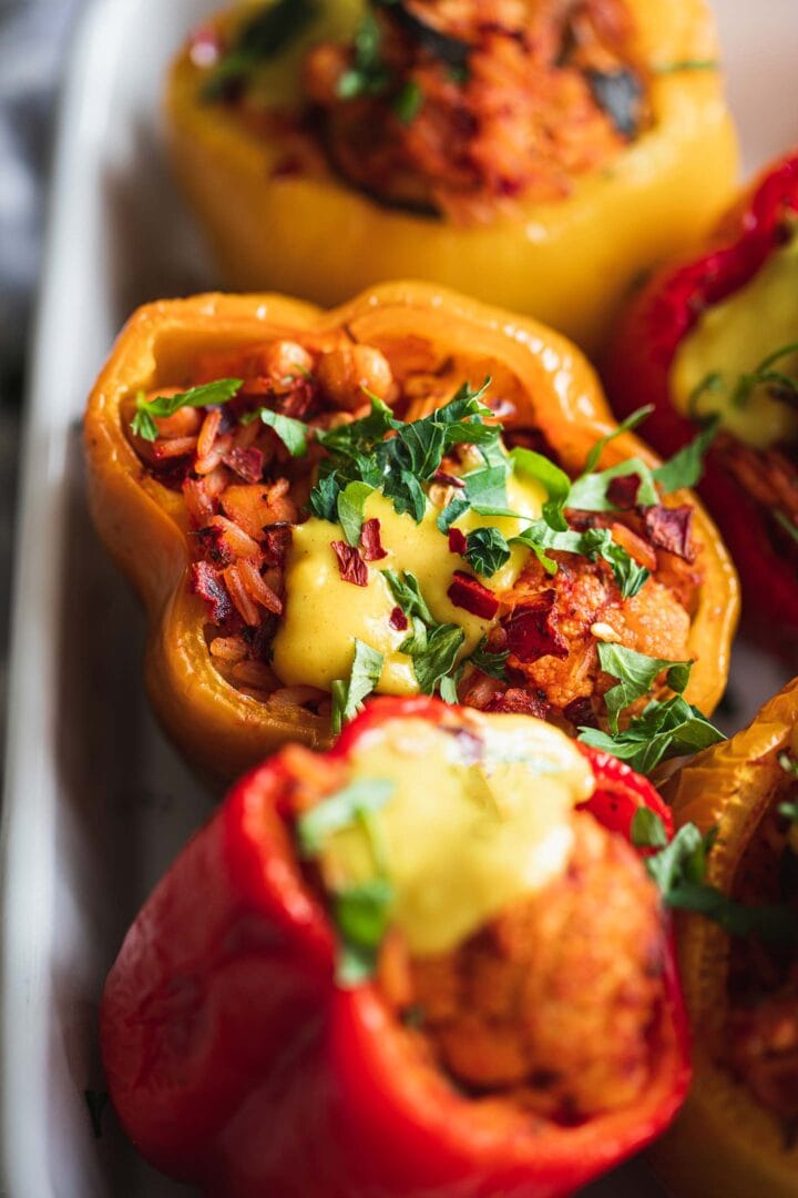 Closeup of stuffed peppers with a dairy-free cheese sauce