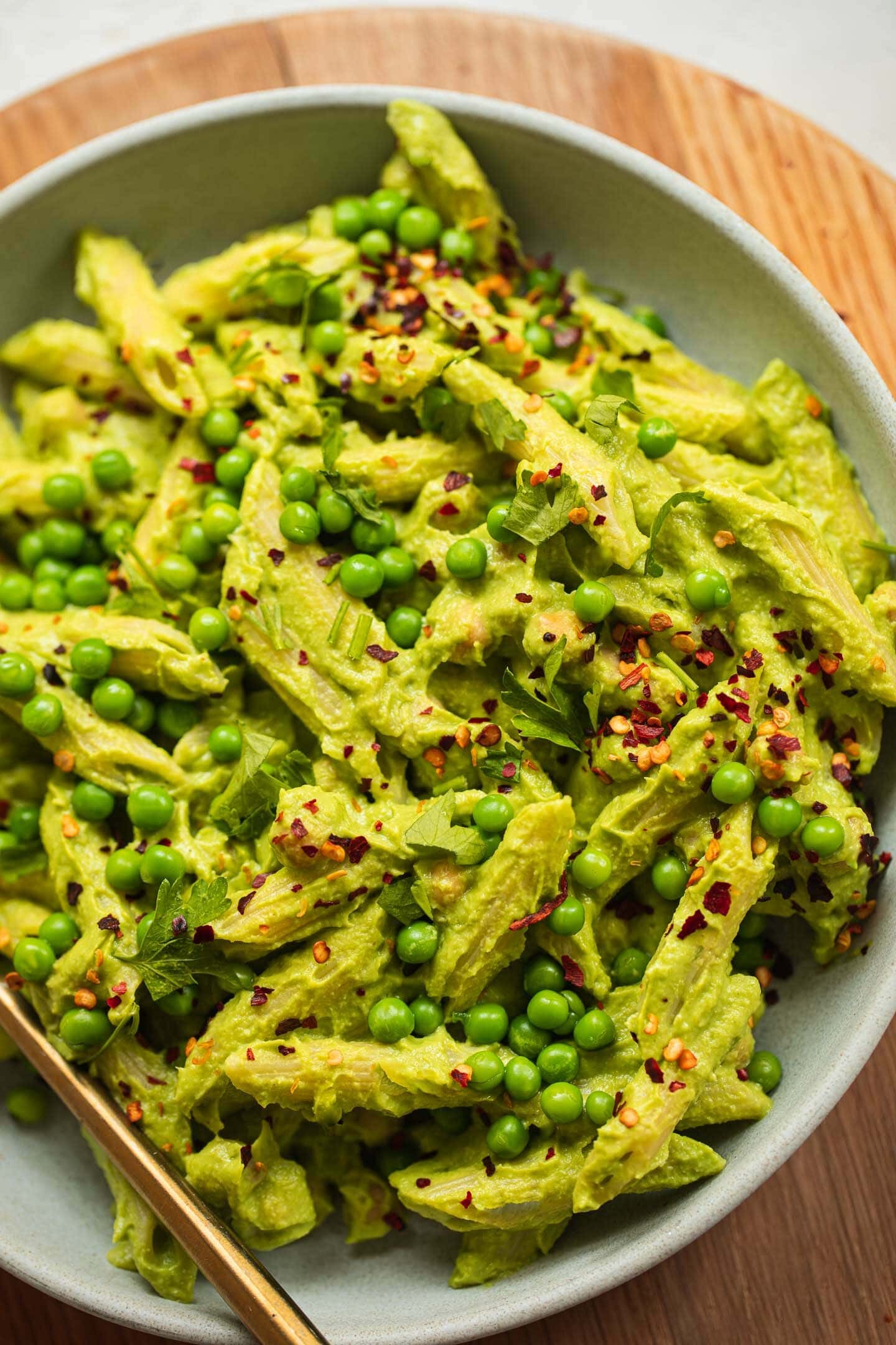 Bowl of avocado pasta with green peas and chickpeas