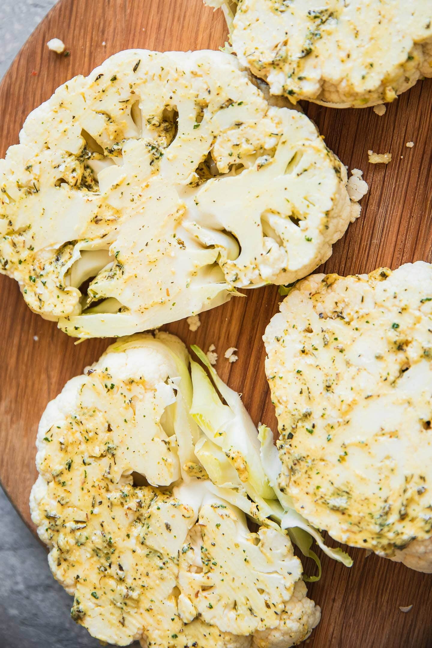Cauliflower steaks with sauce on a wooden board