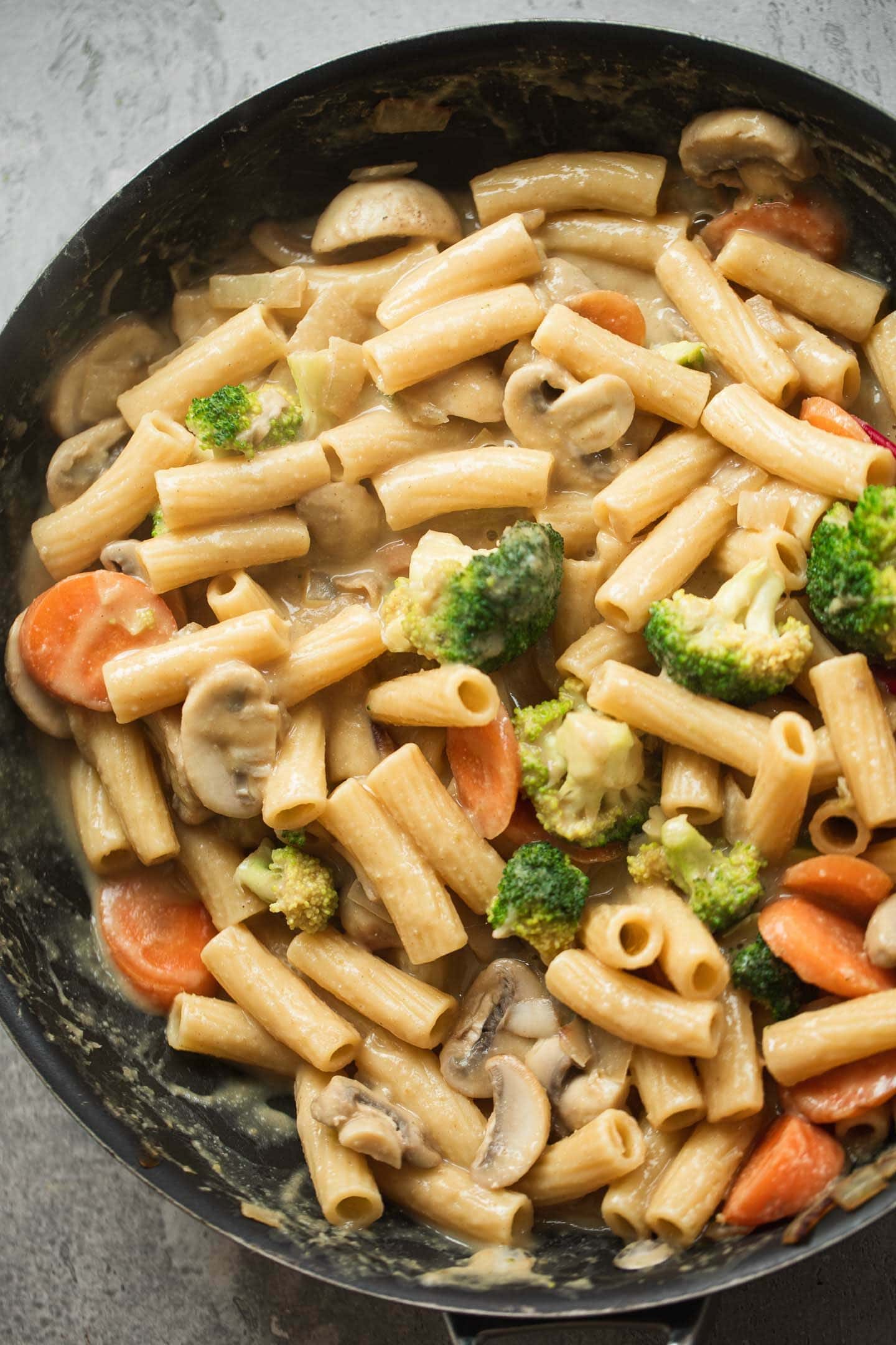 Vegetables, pasta and a creamy sauce in a frying pan