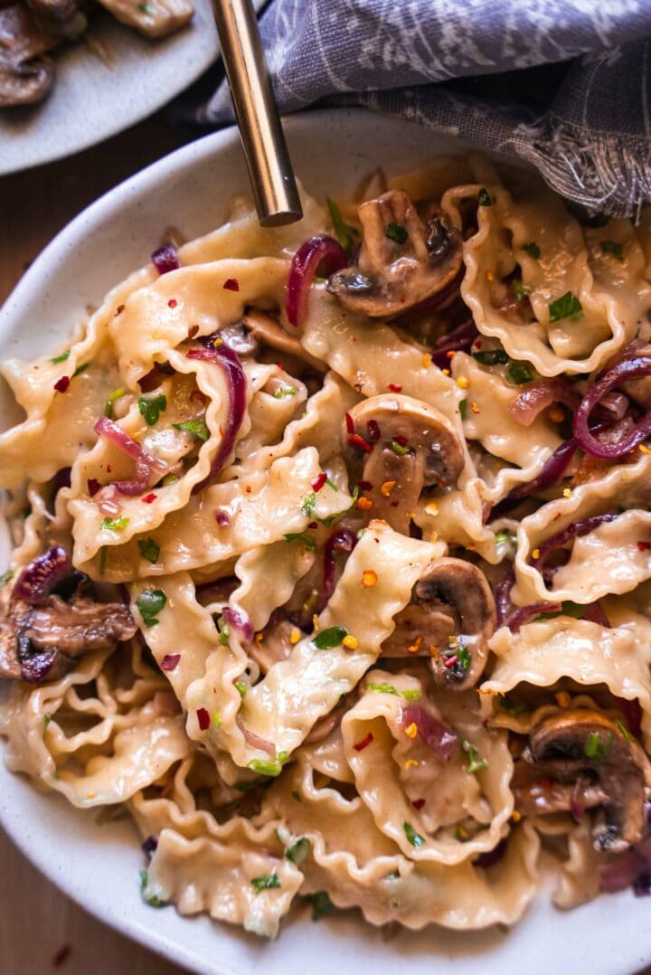 Bowl of pasta with onions and mushrooms