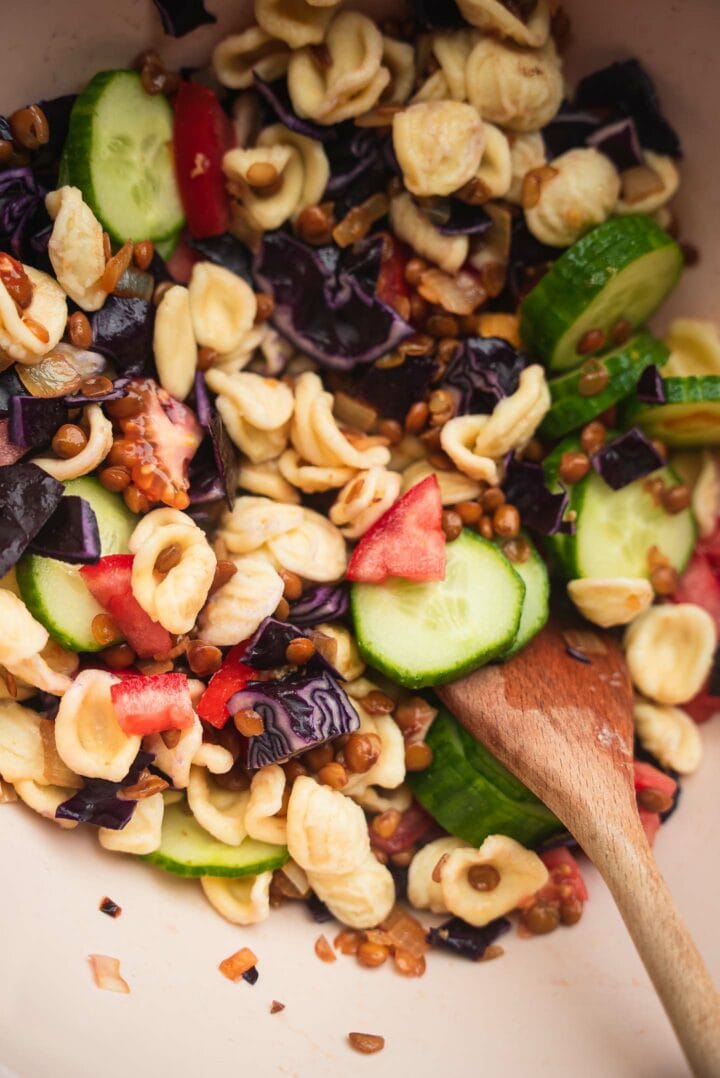Pasta salad with vegetables in a mixing bowl