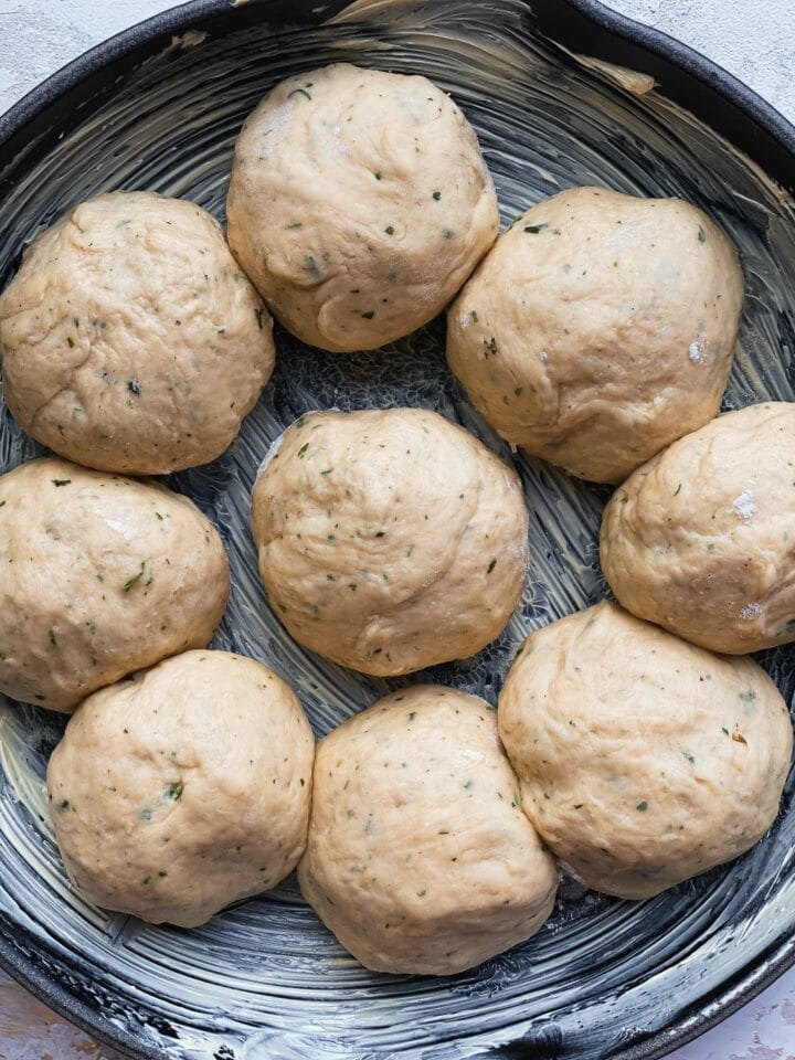 Bread rolls in a skillet before baking