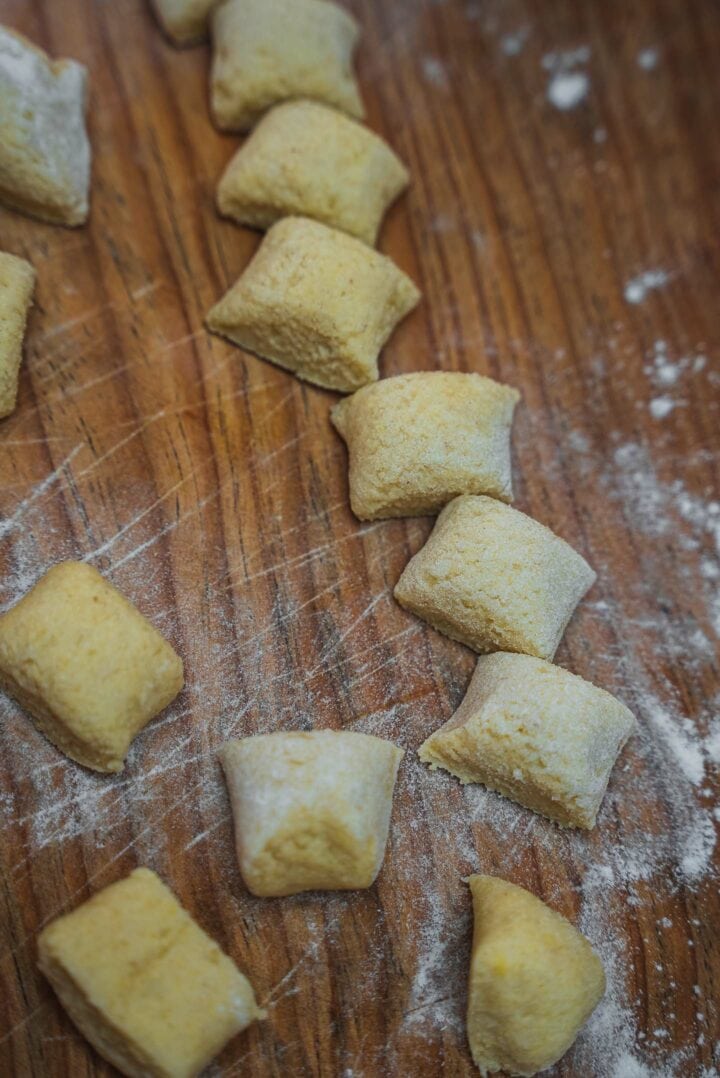 Uncooked gnocchi on a wooden board