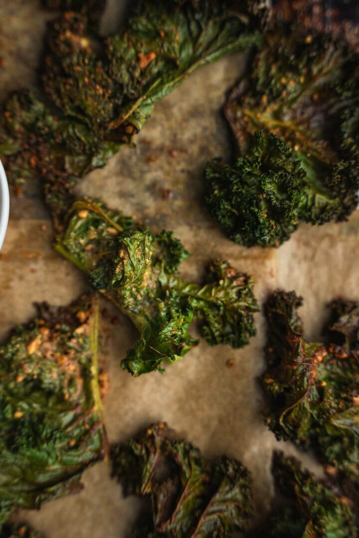 Kale on a baking tray with peanut sauce