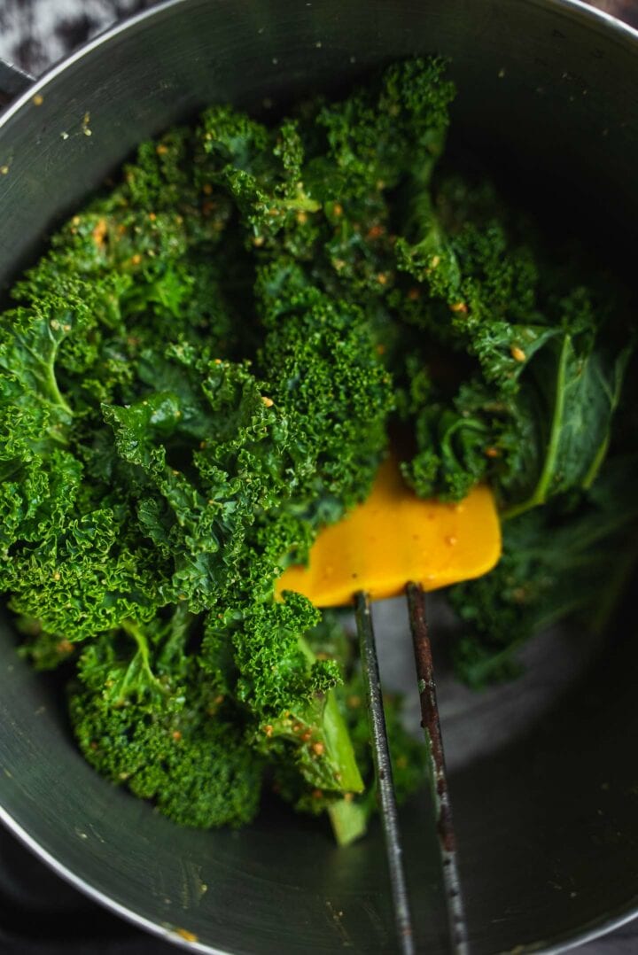 Kale with peanut sauce in a mixing bowl